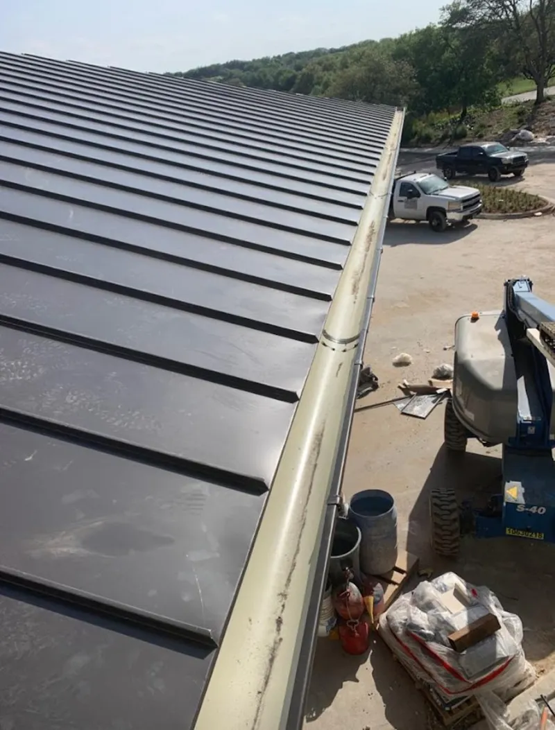 Standing seam panel and gutter detail on a metal roofing jobsite in Temple